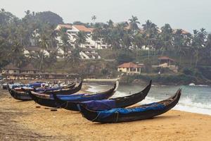 Fishing boat on the beach the ocean on a background of palm trees in Kovalam, Kerala, India. Copy, empty space for text photo
