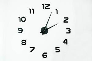esfera de reloj con manecillas negras y números en un fondo blanco foto