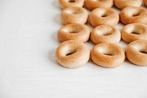 Drying or mini round bagels on a white wooden background. Top view. Copy, empty space for text photo