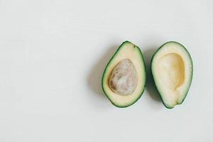 Sliced avocado on a white wooden background. Top view. Copy, empty space for text