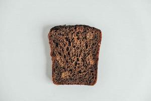 Slic of fresh brown bread with raisins on a white wooden background. Top view. Copy, empty space for text photo