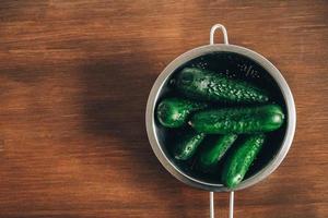 Fresh green cucumbers on a wooden table background. Top view. Copy, empty space for text photo