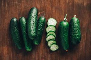 Fresh cucumbers slices on a wooden background. Top view. Copy, empty space for text photo