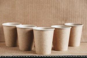 Disposable paper cups on kraft paper background photo
