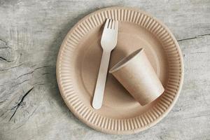 Wooden fork and paper cup with plate on wooden background photo