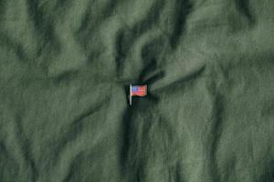 USA flag pin badge on green fabric background photo