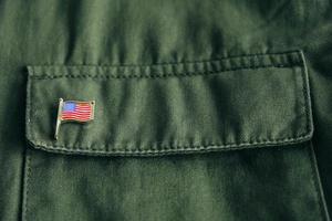 USA flag pin badge on green jacket pocket photo