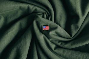 USA flag pin badge on green fabric background photo