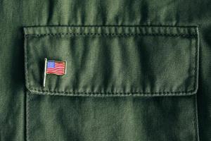 USA flag pin badge on green jacket pocket photo