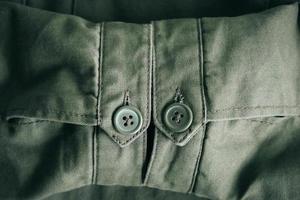 Background of folding sleeves of green jacket and buttons with seam line photo