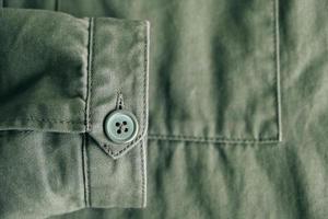 Background of folding sleeve of green jacket on pocket and buttonhole with seam line photo