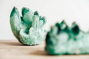 Raw emerald and gemstone rough rock crystal on a wooden table photo