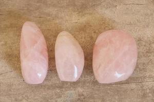 cristales pulidos piedras preciosas de cuarzo rosa sobre fondo de madera foto