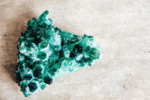 Raw emerald and gemstone rough rock crystal on a wooden table photo