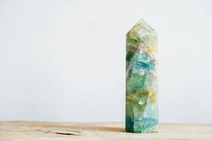 Esmeralda cruda y cristal de roca en bruto de piedras preciosas sobre una mesa de madera foto