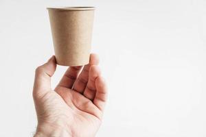 Men hand holding a paper cup on white background photo