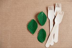 Wooden forks on a cardboard background. Eco friendly disposable tableware. Top view. Copy, empty space for text photo