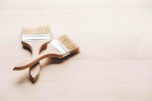 Two paint brushes with a wooden handle and natural bristles on a wooden background photo