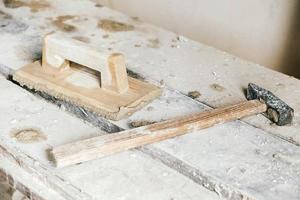 herramientas de construcción antiguas para yeso en banco de madera vintage. paletas y otras herramientas de albañilería. copiar, espacio vacío para texto foto