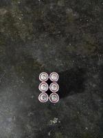 batteries lined up against a cement floor background photo