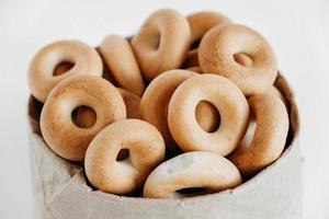 Drying or round bagels in a paper bag on a white wooden background. Copy, empty space for text photo
