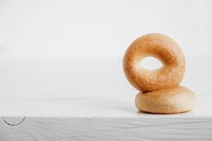 Drying or mini round bagels on a white wooden background. Copy, empty space for text photo