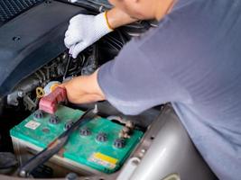 Mechanic holding a block wrench handle while fixing a car. photo