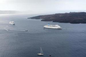 Beautiful landscape with sea views. Cruise ship in sea near NEA Kameni, a small Greek island in the Aegean sea near Santorini. photo