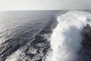 Trail on water surface behind of fast moving motor boat photo