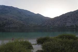 las montañas y el lago con la puesta de sol. foto