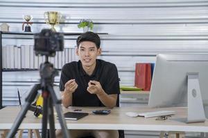Hombre asiático blogger presenta y revisa la transmisión de video del producto en vivo en una red social. blogs, vlogs, compras en línea y concepto de redes sociales foto