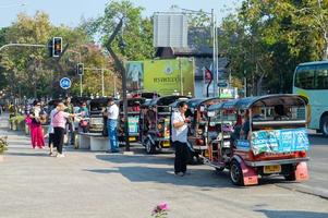 chiang mai tailandia10 de enero de 2020un grupo de turistas que toman un coche tuktuk se bajan del autobús para viajar en chiang mai. Los tuktuks están disponibles en muchos destinos de Tailandia. foto