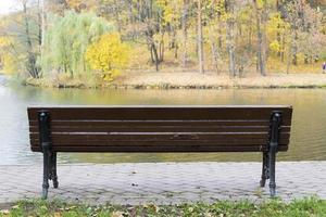 A Park bench overlooking the lake in autumn day. photo