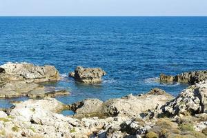 The waves breaking on a stony beach, forming a spray. Wave and splashes on beach. Waves crashing onto rocks. photo