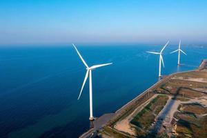 Aerial view of the wind turbines. Green ecological power energy generation. Wind farm eco field. Offshore and onshore windmill farm green energy at sea