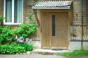 Yellow wooden entrance door with handle in yellow brick wall building photo