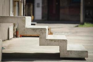 Gray concrete stairway up without railings with deep shadow underneath photo