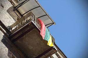 Lithuanian flag hanging from balcony on blue sky photo