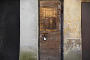 Old weathered locked wooden door with padlock photo