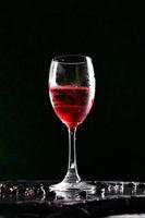 cócteles alcohólicos a base de zumos de frutos rojos y soda. vertido en una copa de vino por un camarero profesional. foto