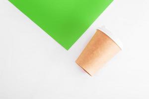 coffee cup of reusable materials next to colored paper on white background. zero waste concept photo