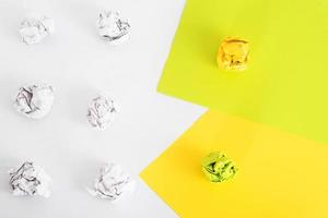 overhead shot of crumpled paper in oder and colored flat sheets of paper on white background. zero waste concept photo