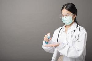 woman doctor is using hand sanitizer photo