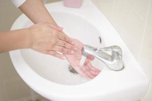 una mujer se lava las manos foto