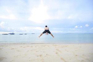 hombre feliz disfrutando y relajándose en el concepto de playa, verano y vacaciones foto