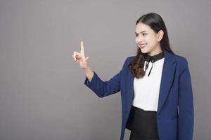 retrato de una hermosa mujer morena de negocios en un estudio de fondo gris foto