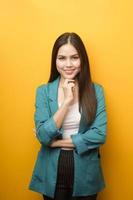 portrait of beautiful business woman in green suit on yellow background photo