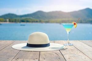 fondo de verano, sombrero blanco y bebida de verano en la playa