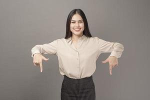 Portrait of Beautiful business woman is showing something on gray background photo