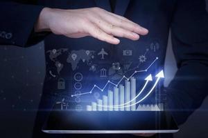 Businessman is holding financial growth graph and analyzing business data, business plan and strategy concept . photo